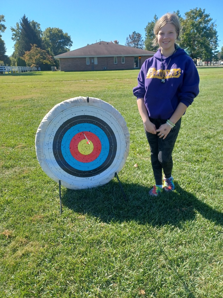 Student standing by archery target